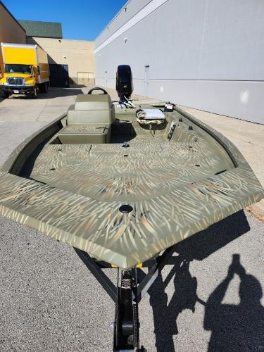 Tracker Grizzly 1754 SC 2025 Tracker Grizzly 1754 SC boat with camouflage design parked outdoors.
