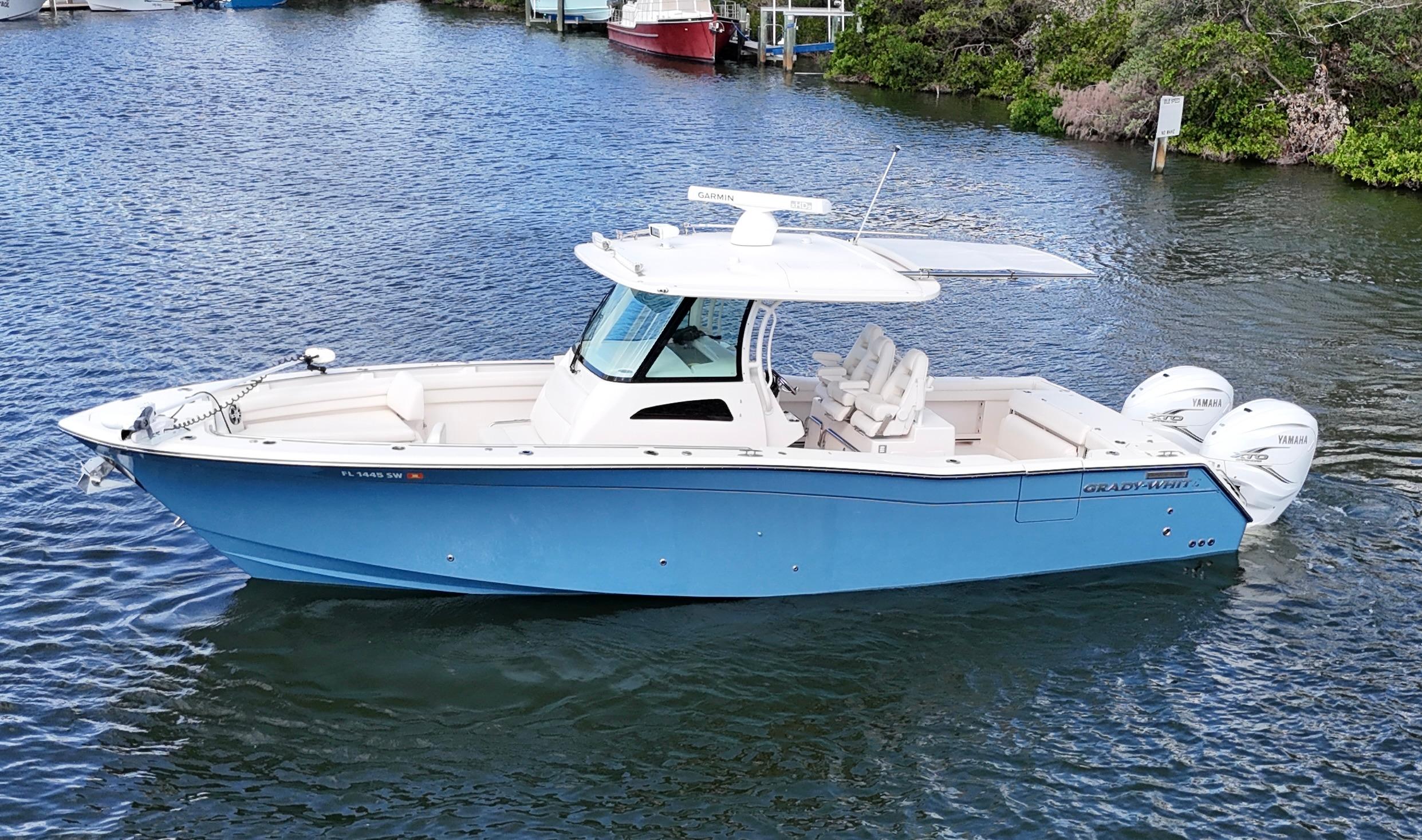 Grady-White Canyon 336 2021 Grady-White Canyon 336 boat on water, featuring a sleek blue hull and twin Yamaha engines.