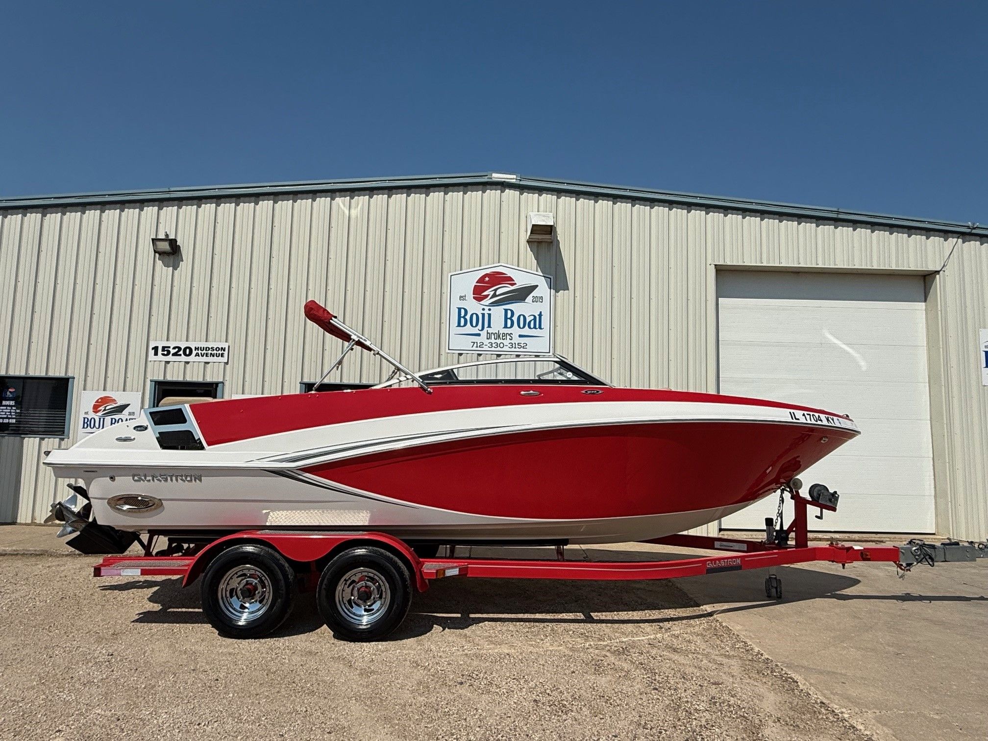 Glastron GT 245 2014 Glastron GT 245 boat in red and white on a trailer outside Boji Boat.
