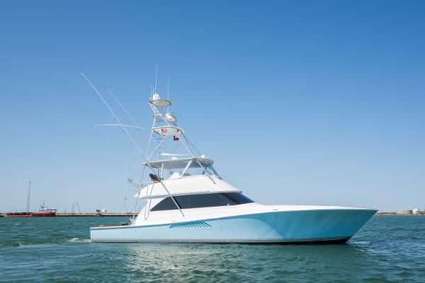 Viking Convertible 2001 Viking Convertible yacht cruising on open water under clear blue sky.