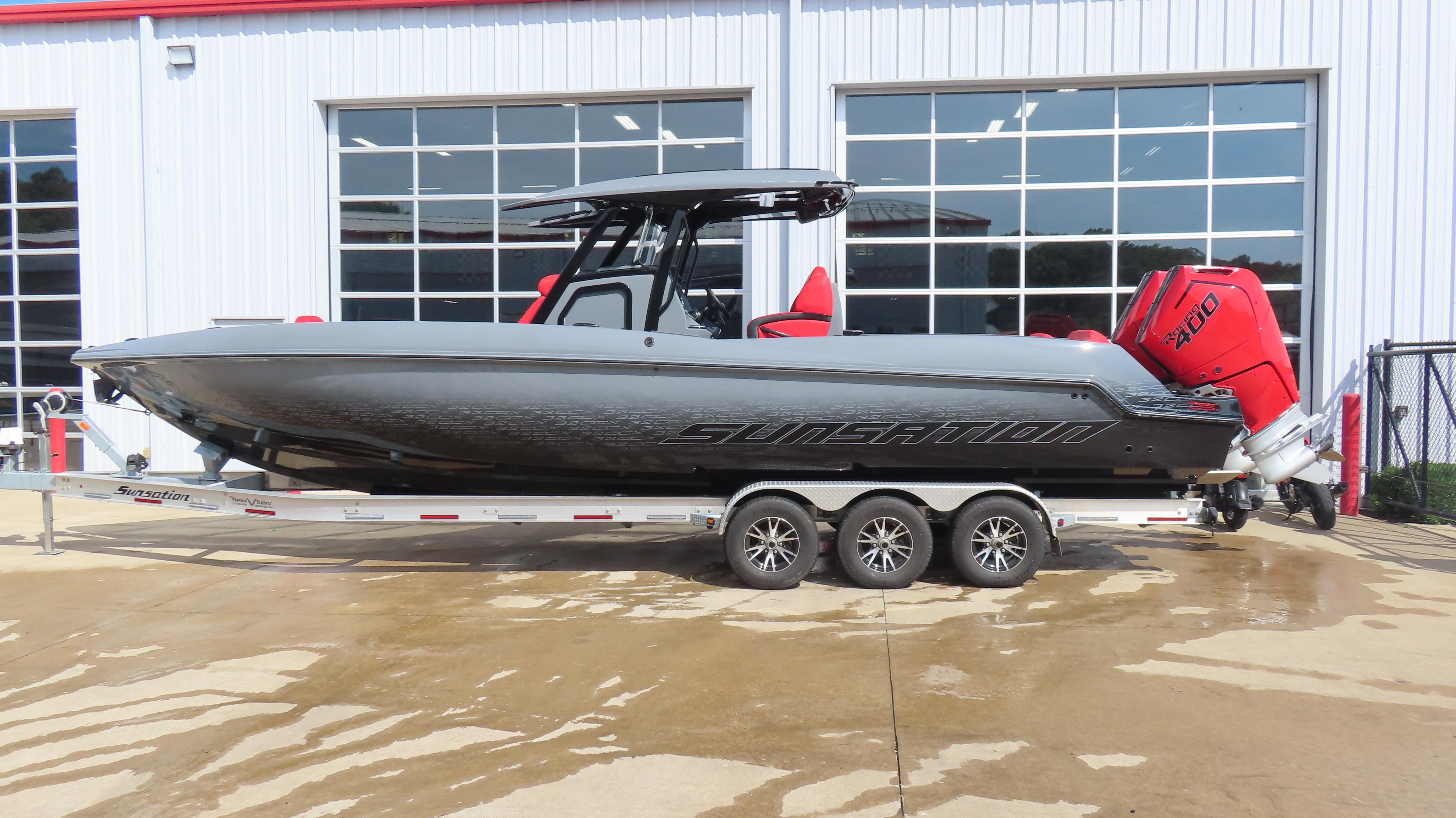 Sunsation 32 CCX 2025 Sunsation 32 CCX boat on trailer, parked outside a building.