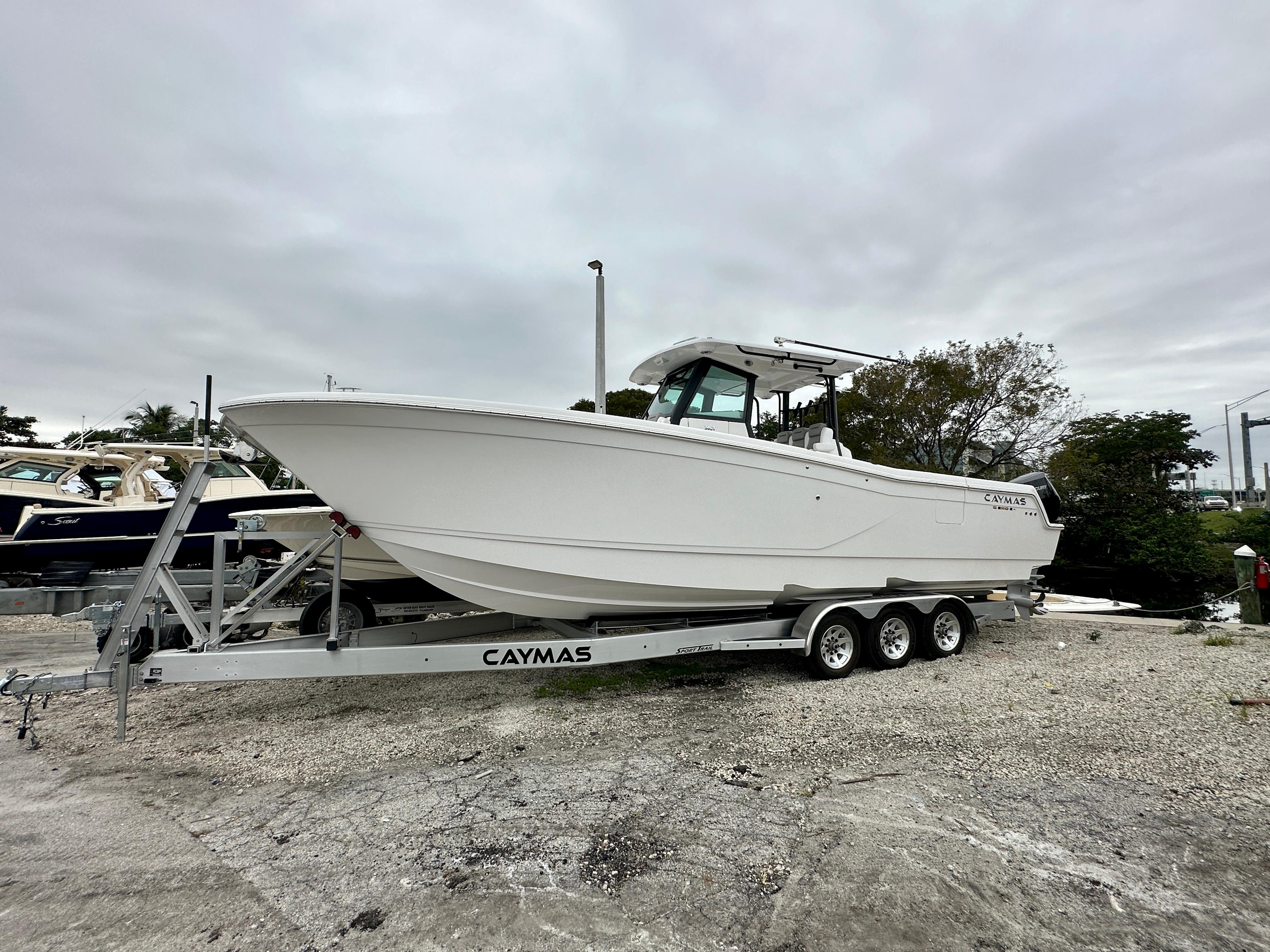 Caymas 34 CT 2024 Caymas 34 CT boat on trailer, parked outdoors under cloudy sky.