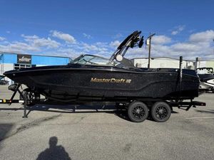 MasterCraft XT24 2025 MasterCraft XT24 boat on trailer, black exterior, parked outdoors.