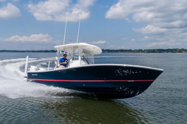 Regulator 30XO 2024 Regulator 30XO boat cruising on a lake under a partly cloudy sky.