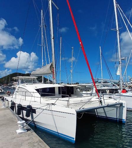 Leopard 48 2018 Leopard 48 catamaran docked in a sunny marina, featuring sleek design and spacious deck.