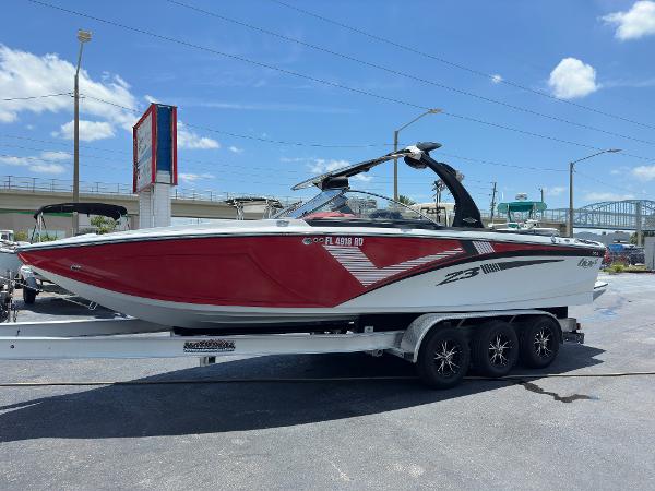 Tigé Z3 2015 Tigé Z3 boat on a trailer, red and white exterior, parked outdoors.
