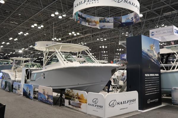 Sailfish 245 DC 2025 Sailfish 245 DC boat displayed at a boat show, surrounded by promotional materials.