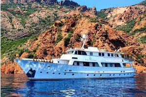Van den Akker Displacment 1966 Full Displacement Motor Yacht in scenic rocky coastal waters.