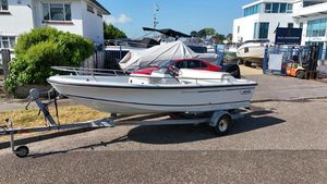 Boston Whaler Rage 15 1995 Boston Whaler Rage 15 boat on trailer, parked outdoors near marina.