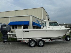 Parker 2420 Sport Cabin 2025 Parker 2420 Sport Cabin boat on trailer, parked outside a building with blue awnings.