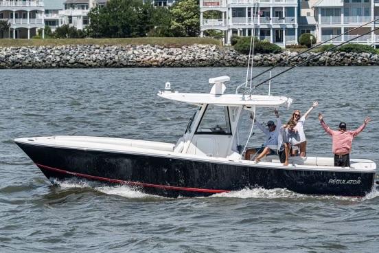 Regulator Center Console 2021 Regulator Center Console boat cruising with passengers waving.