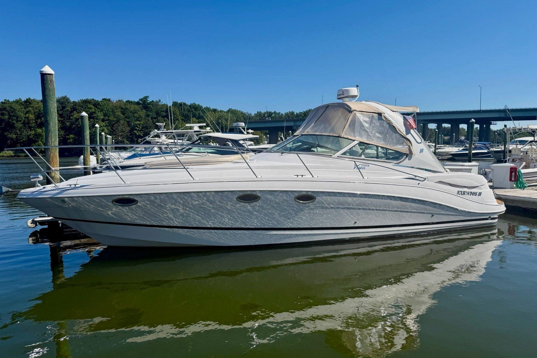 Four Winns 348 Vista 2005 Four Winns 348 Vista boat docked in a marina under clear blue skies.