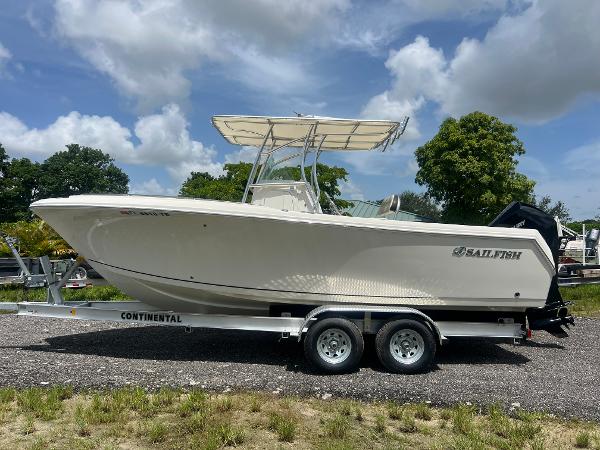 Sailfish 242 CC 2022 Sailfish 242 CC boat on trailer, parked outdoors under a partly cloudy sky.