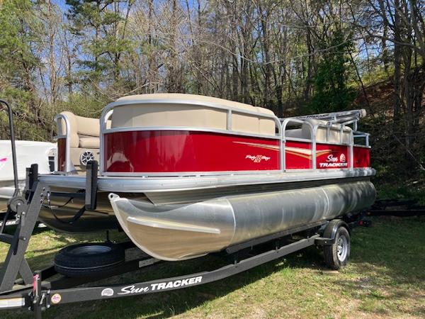 Sun Tracker Party Barge 18 DLX 2025 Sun Tracker Party Barge 18 DLX pontoon boat on trailer, parked outdoors.