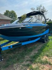 Centurion Fi23 2022 Centurion Fi23 boat on trailer, black and blue design, parked outdoors.