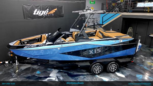 Axis T220 2024 Axis T220 boat in showroom, blue and black design, on trailer.