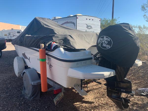 Bayliner Element E18 2017 Bayliner Element E18 boat covered, parked near RVs, with "Bite Me" text on the stern.