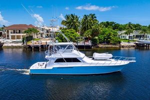 Bertram 60 Convertible 1998 Bertram Convertible yacht cruising near waterfront homes and palm trees.