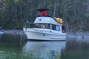 Camano Troll 2000 Camano Troll boat named "Hilda Mary" anchored in a serene forested lake.