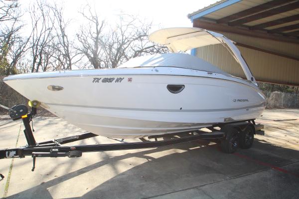 Regal LS6 2020 Regal LS6 boat on trailer under shelter, side view.