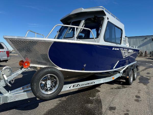 Hewescraft 210 Sea Runner ET HT 2025 Hewescraft 210 Sea Runner ET HT boat on trailer, blue and silver design.