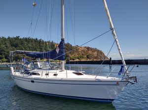 Catalina 36 MkII Catalina 36 MkII sailboat from 2002 on calm water near a forested shoreline.