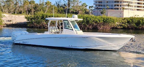 Boston Whaler 350 Outrage 2018 Boston Whaler 350 Outrage boat cruising on a sunny day near lush greenery.