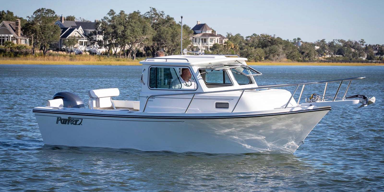 Parker 2220 SC 2026 Parker 2220 SC boat cruising on a calm lake near waterfront homes.