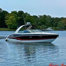 Formula 310 Sun Sport 2015 Formula 310 Sun Sport boat on a serene lake with lush green trees.