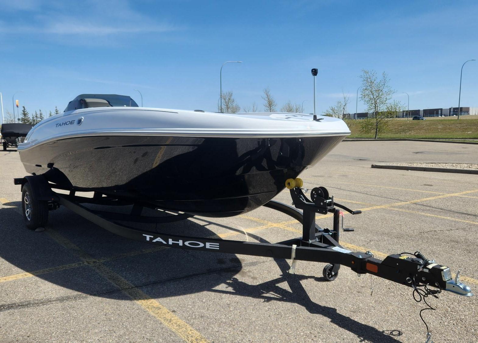 Tahoe T18 2025 Tahoe T18 boat on trailer in parking lot under clear blue sky.
