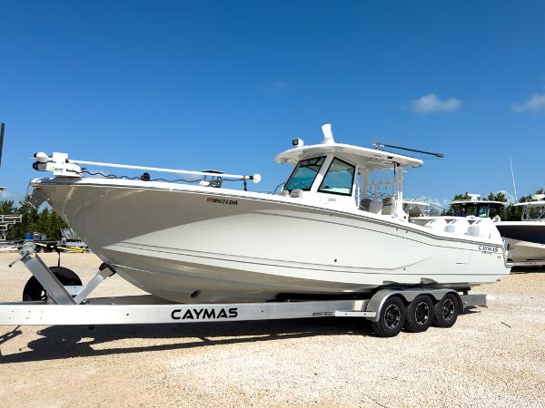 Caymas 341 CC 2023 Caymas 341 CC boat on a trailer under a clear blue sky.
