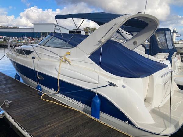 Bayliner 3055 Ciera 2004 Bayliner 3055 Ciera boat docked with blue canopy and fenders.