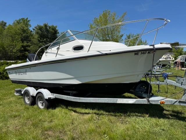 Boston Whaler 205 Eastport 2005 Boston Whaler 205 Eastport boat on trailer, parked on grass.