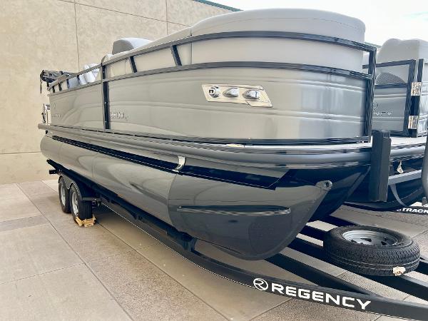 Regency 230 DL3 2023 Regency 230 DL3 pontoon boat on trailer, side view.