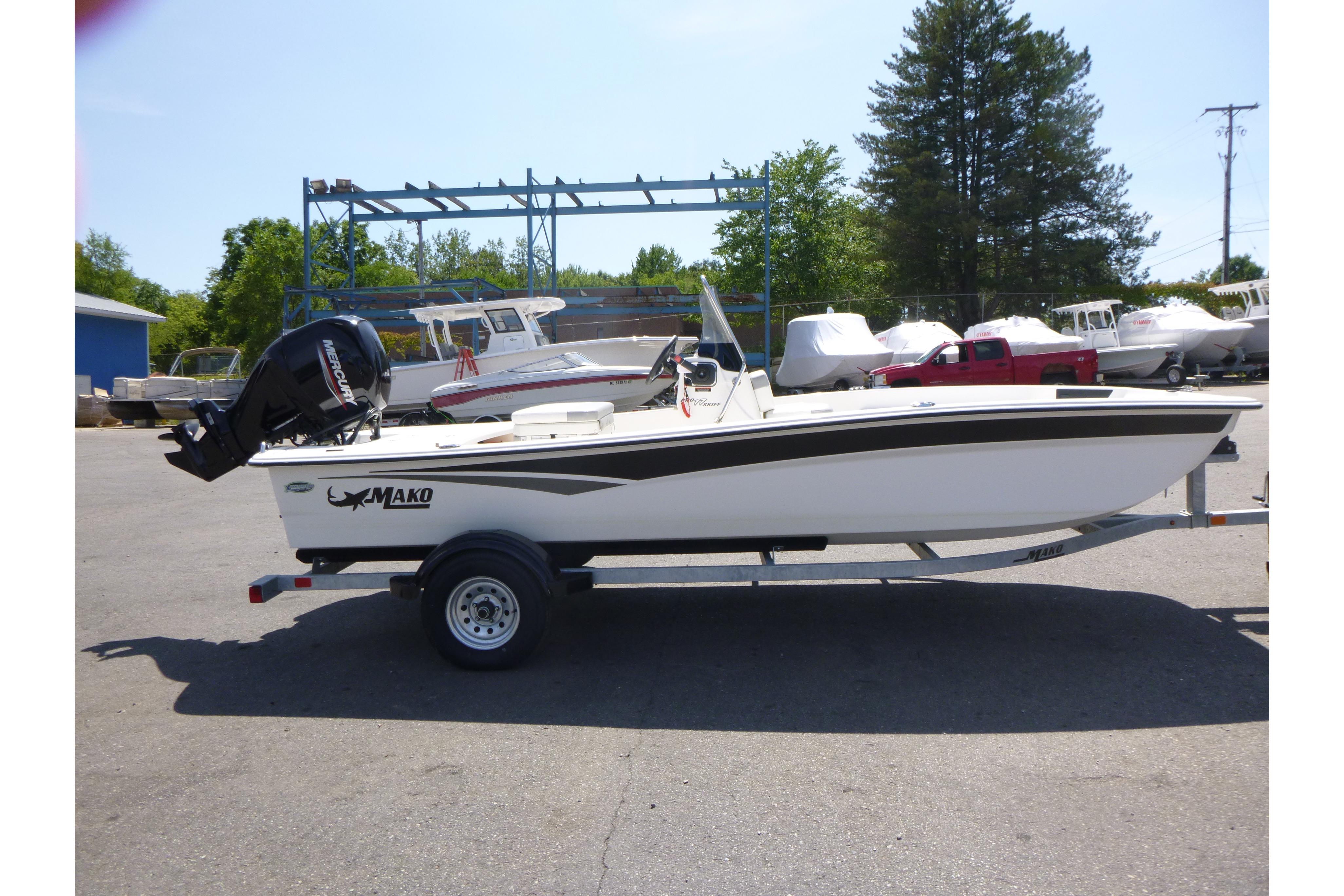 Mako Pro Skiff 17 CC 2024 Mako Pro Skiff 17 CC boat on trailer, parked outdoors.