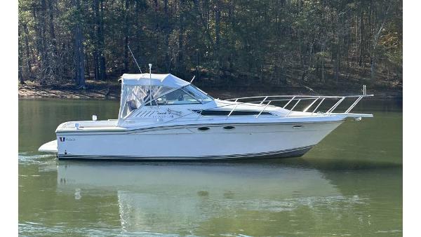Wellcraft 330 Coastal 1991 Wellcraft 330 Coastal boat on calm water, surrounded by trees.
