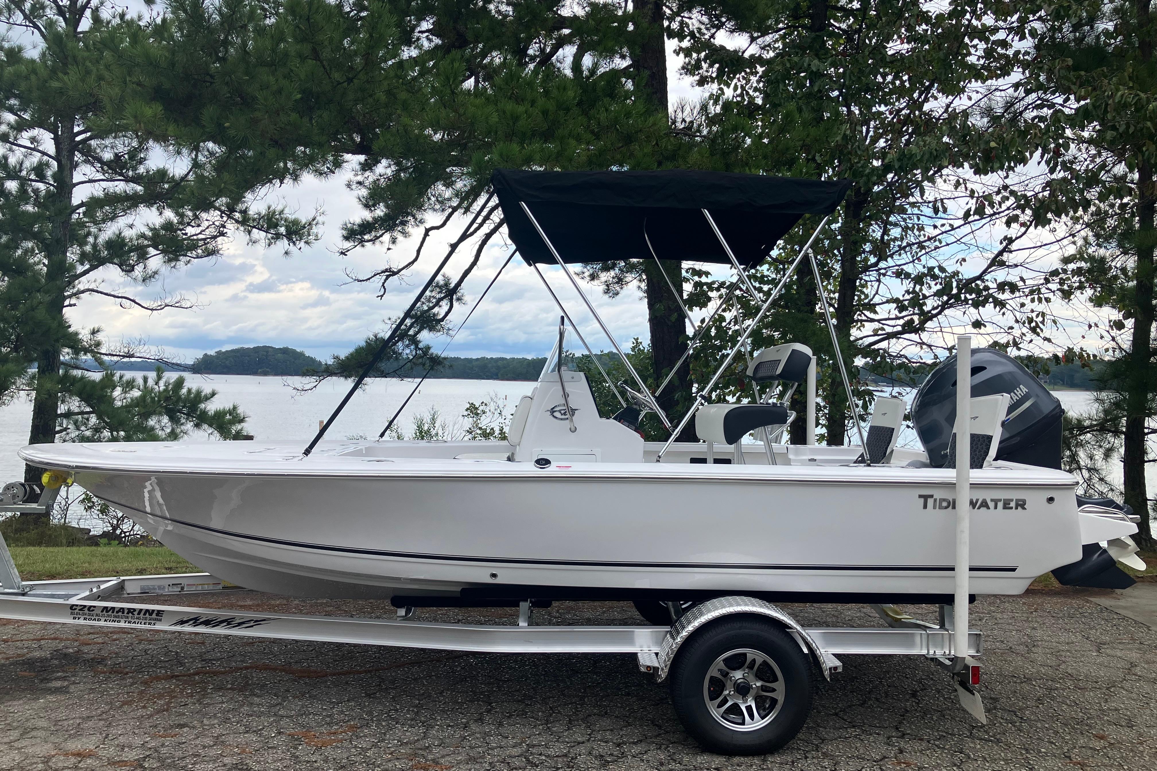 Tidewater 1910 Bay Max 2026 Tidewater 1910 Bay Max boat on trailer by a scenic lake.
