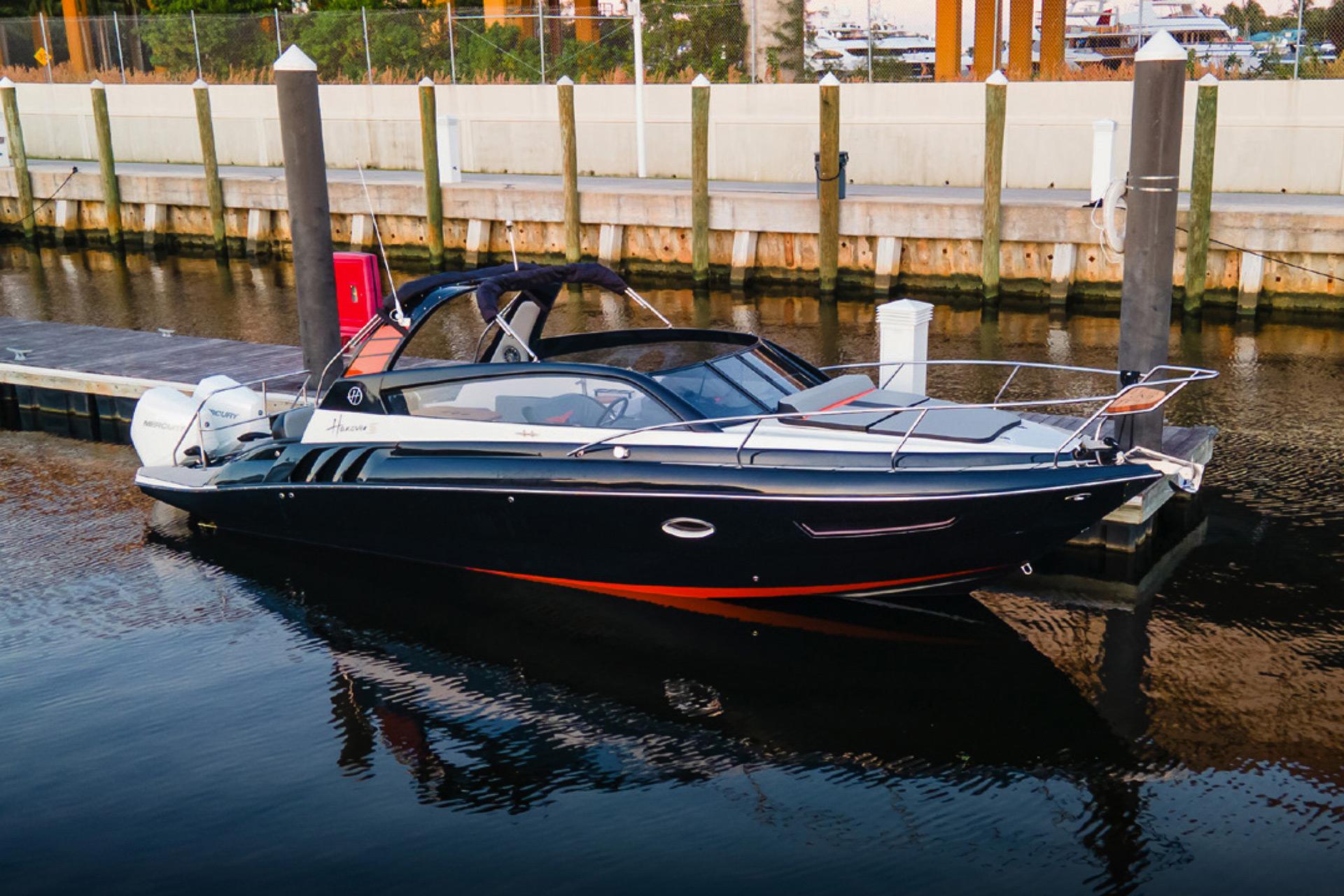 Hanover 305 2024 Hanover 305 boat docked in marina, sleek design, black and orange accents.