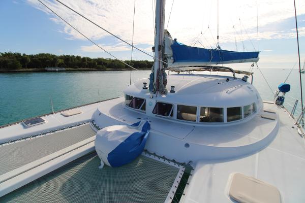 Lagoon 410 2002 Lagoon 410 catamaran on calm water, featuring spacious deck and sails.