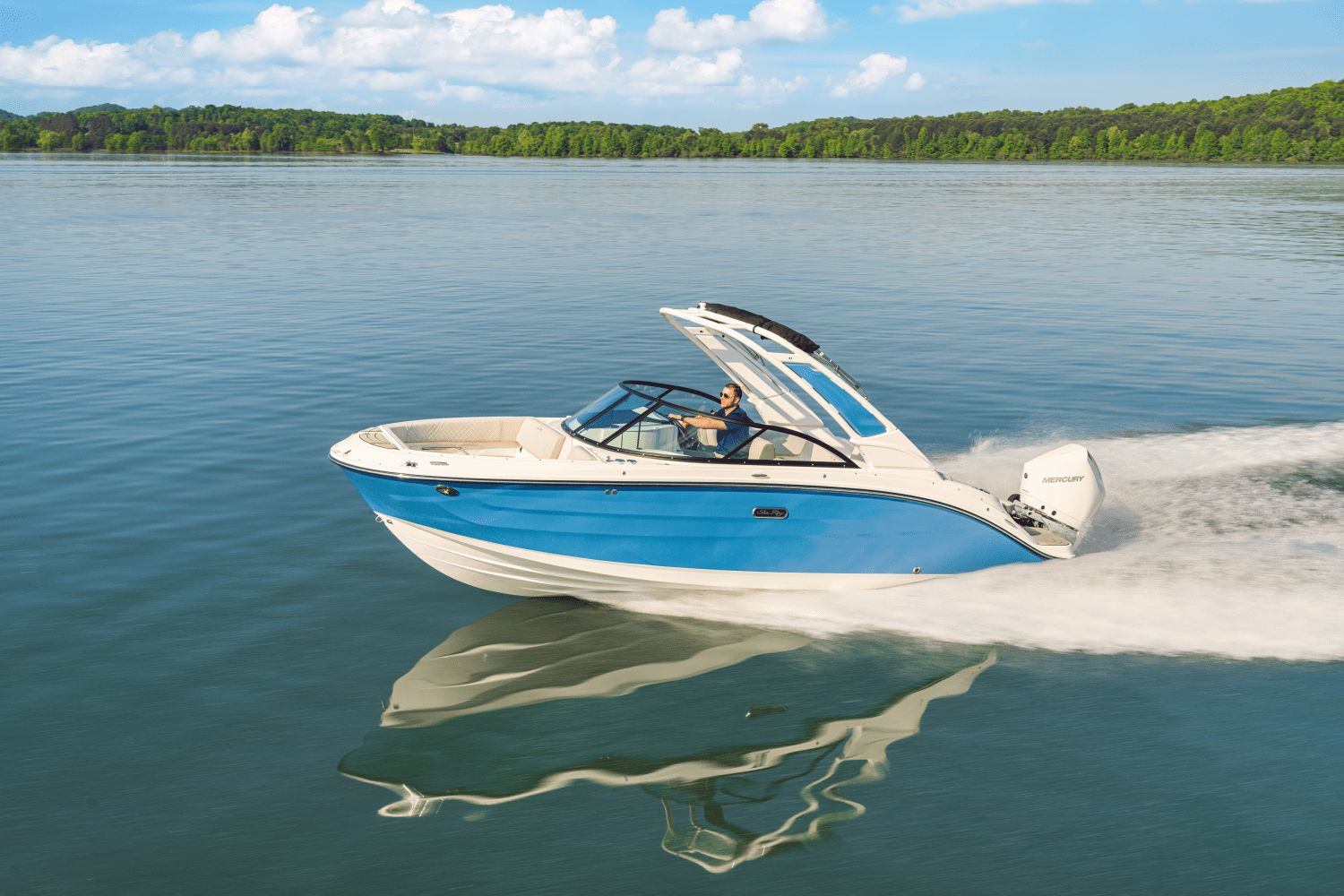 Sea Ray SDX 230 Outboard 2026 Sea Ray SDX 230 Outboard cruising on a serene lake under a clear blue sky.