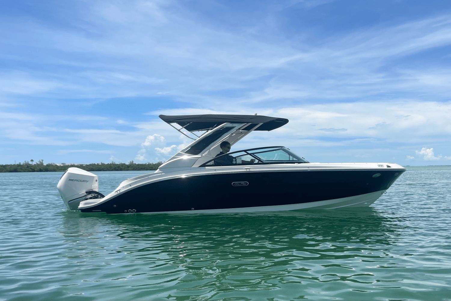 Sea Ray SDX 230 Outboard 2026 Sea Ray SDX 230 Outboard boat on calm water under blue sky.