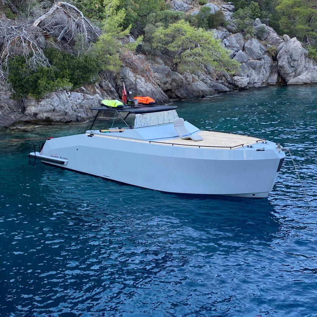 Mazu Yachts 38 2021 Mazu Yachts 38 in serene blue waters near rocky shoreline.