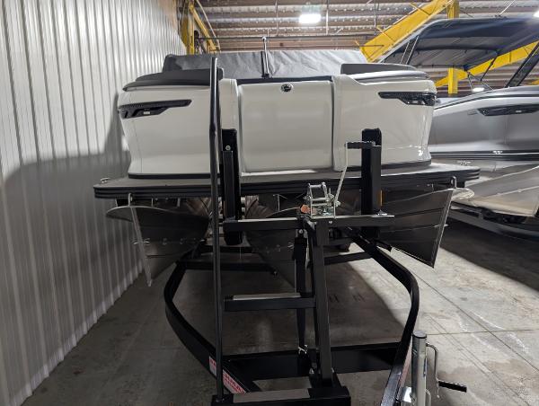 Manitou 22 Aurora Cruise 2025 Manitou 22 CRUISE boat on trailer in indoor storage facility.