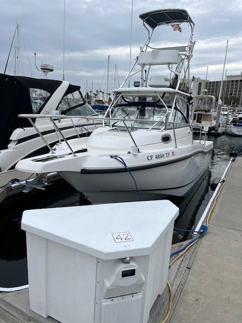Boston Whaler 255 Conquest 2002 Boston Whaler 255 Conquest docked at marina, overcast sky.