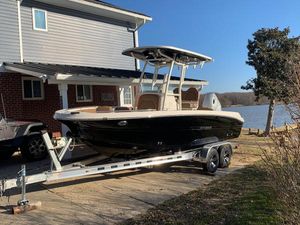 Stingray 216 CC 2021 Stingray 216 CC boat on trailer by lakeside house.