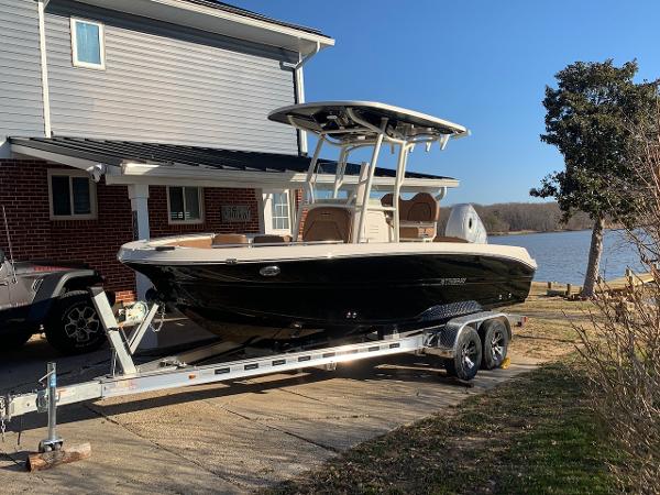 Stingray 216 CC 2021 Stingray 216 CC boat on trailer by lakeside house.