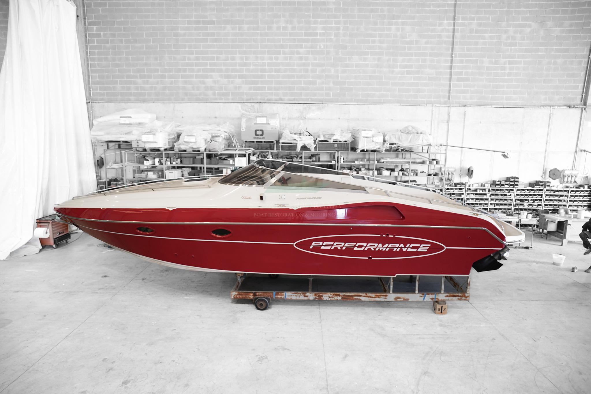 Performance 907 Red Performance 907 speedboat from 2000 in a workshop setting.