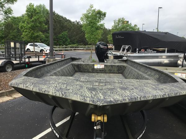 Tracker GRIZZLY 2072 Utility 2025 Tracker GRIZZLY 2072 Utility boat in parking lot, camo design, outboard motor visible.