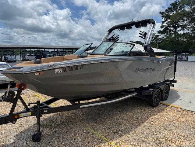 MasterCraft NXT23 2023 MasterCraft NXT23 boat on trailer, parked outdoors under cloudy sky.