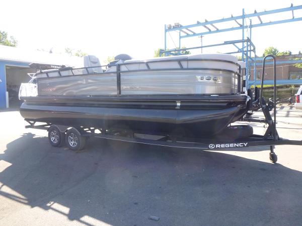 Regency 230 LE3 2024 Regency 230 LE3 pontoon boat on trailer in outdoor setting.